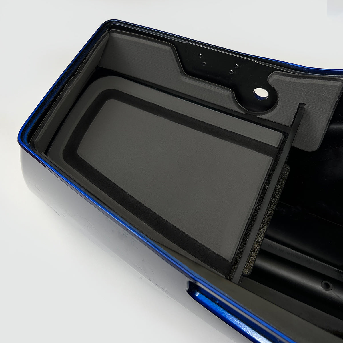 A black and blue motorcycle saddle bag shelf tray kit with a set of keys on it, designed to organize items inside the bag. Charcoal and black version